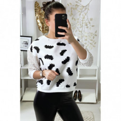 Pull blanc à motif chauve-souris et manches à trou quadrillé.